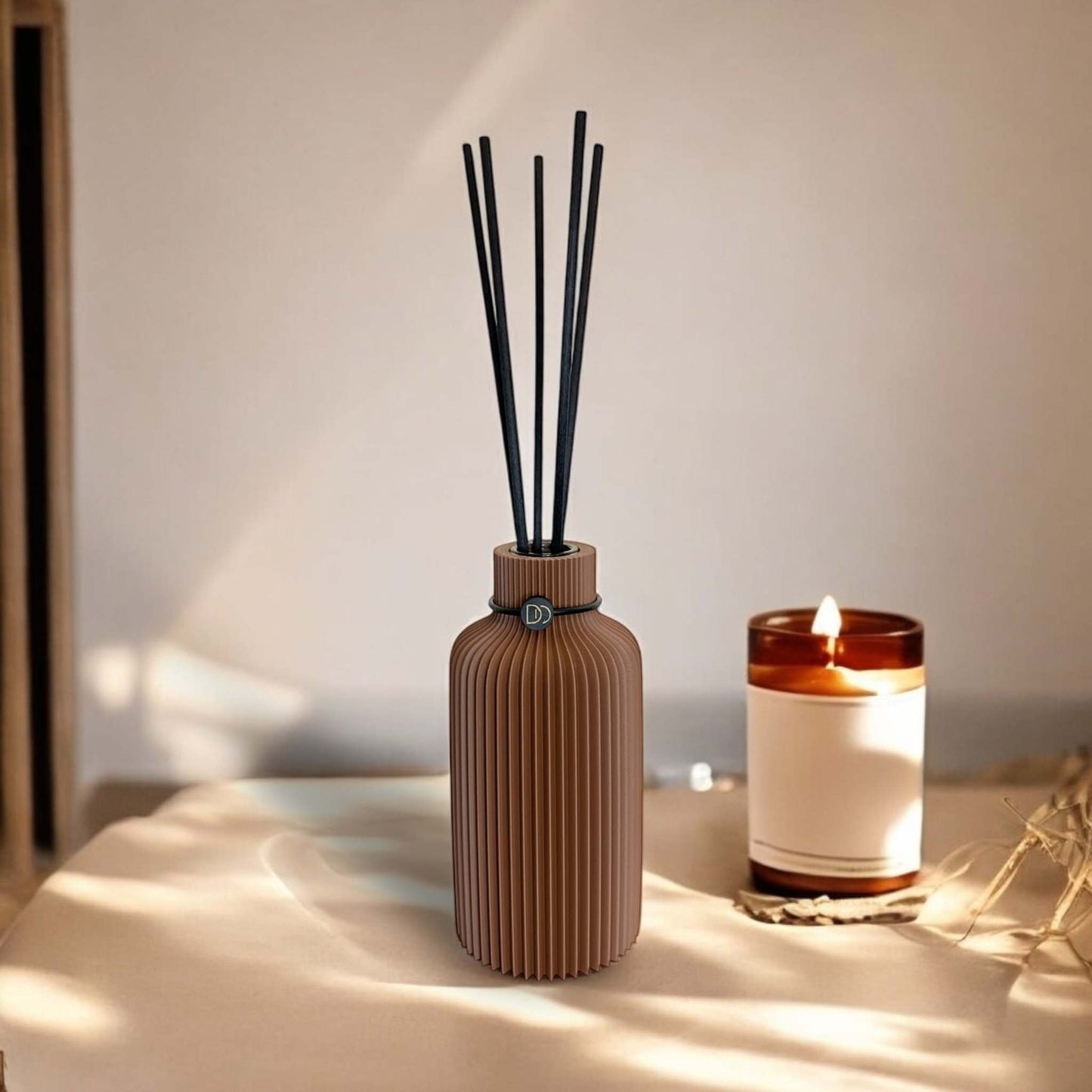 Elegant minimalist diffuser on a table with candle.