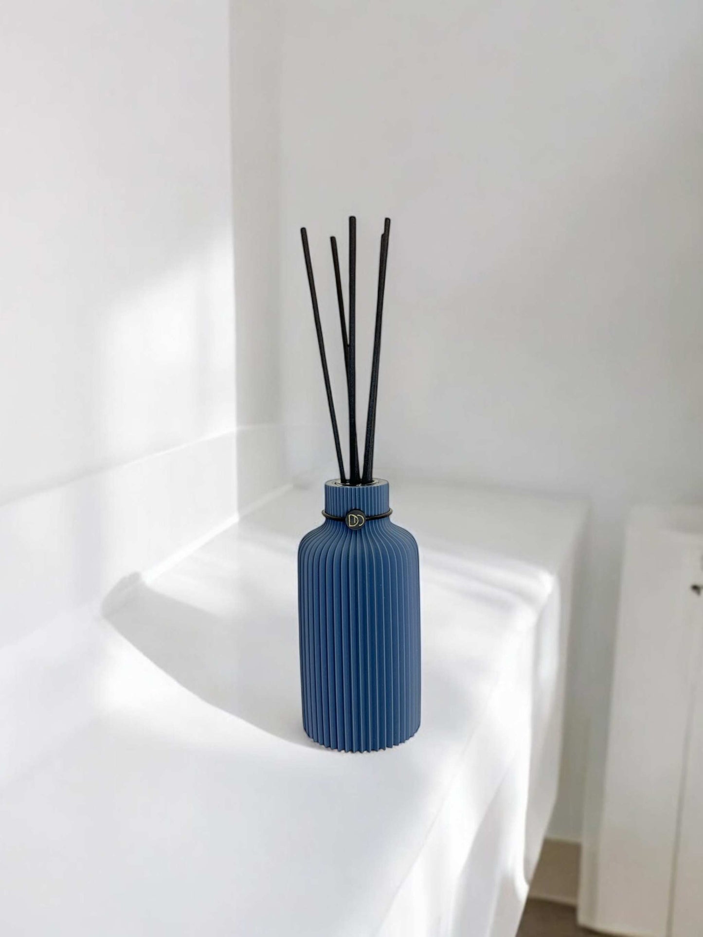Diffuseur minimaliste bleu, design élégant pour parfumer votre intérieur avec sophistication.