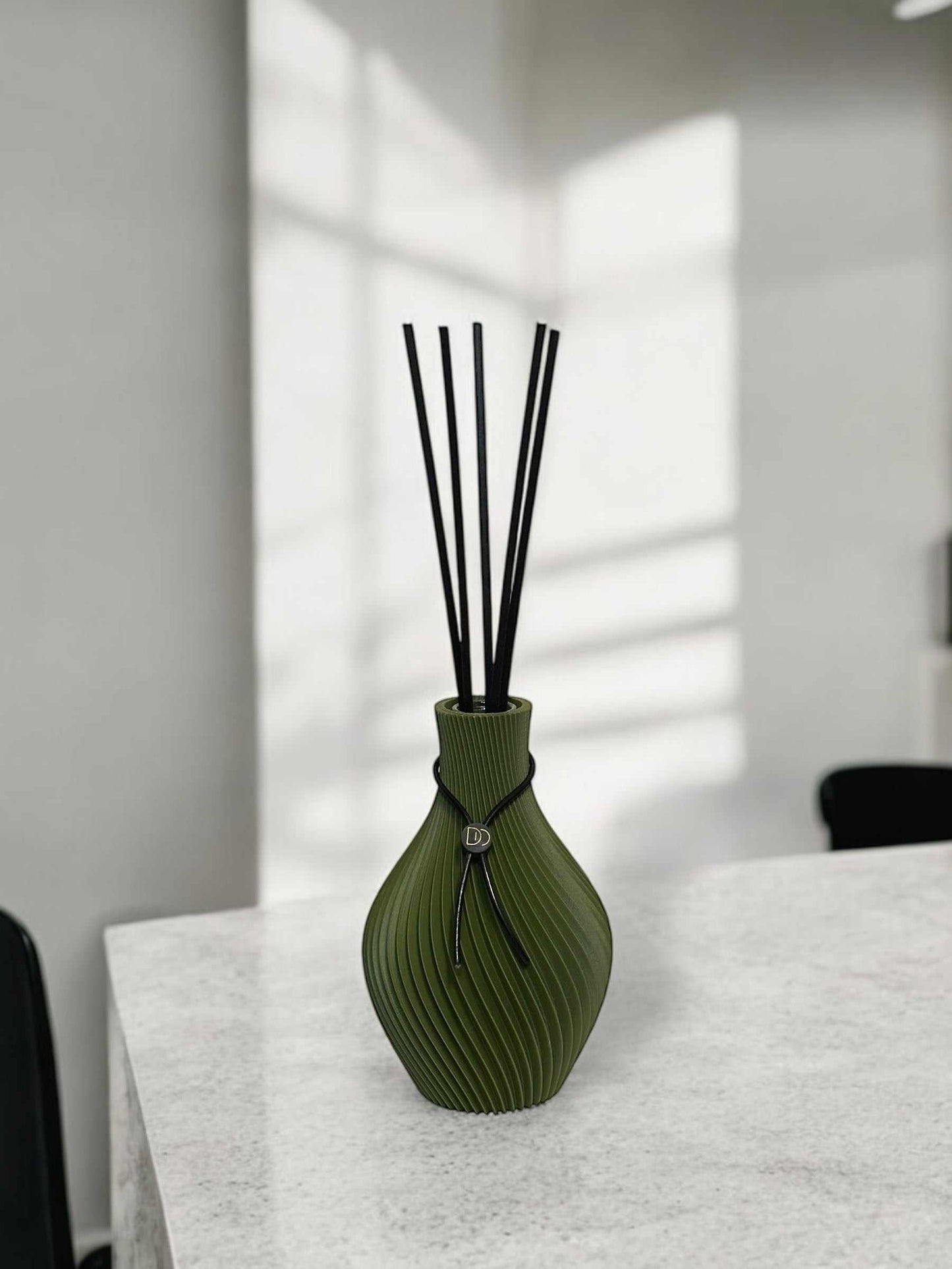 Elegant amphora-shaped diffuser for luxurious home fragrances.