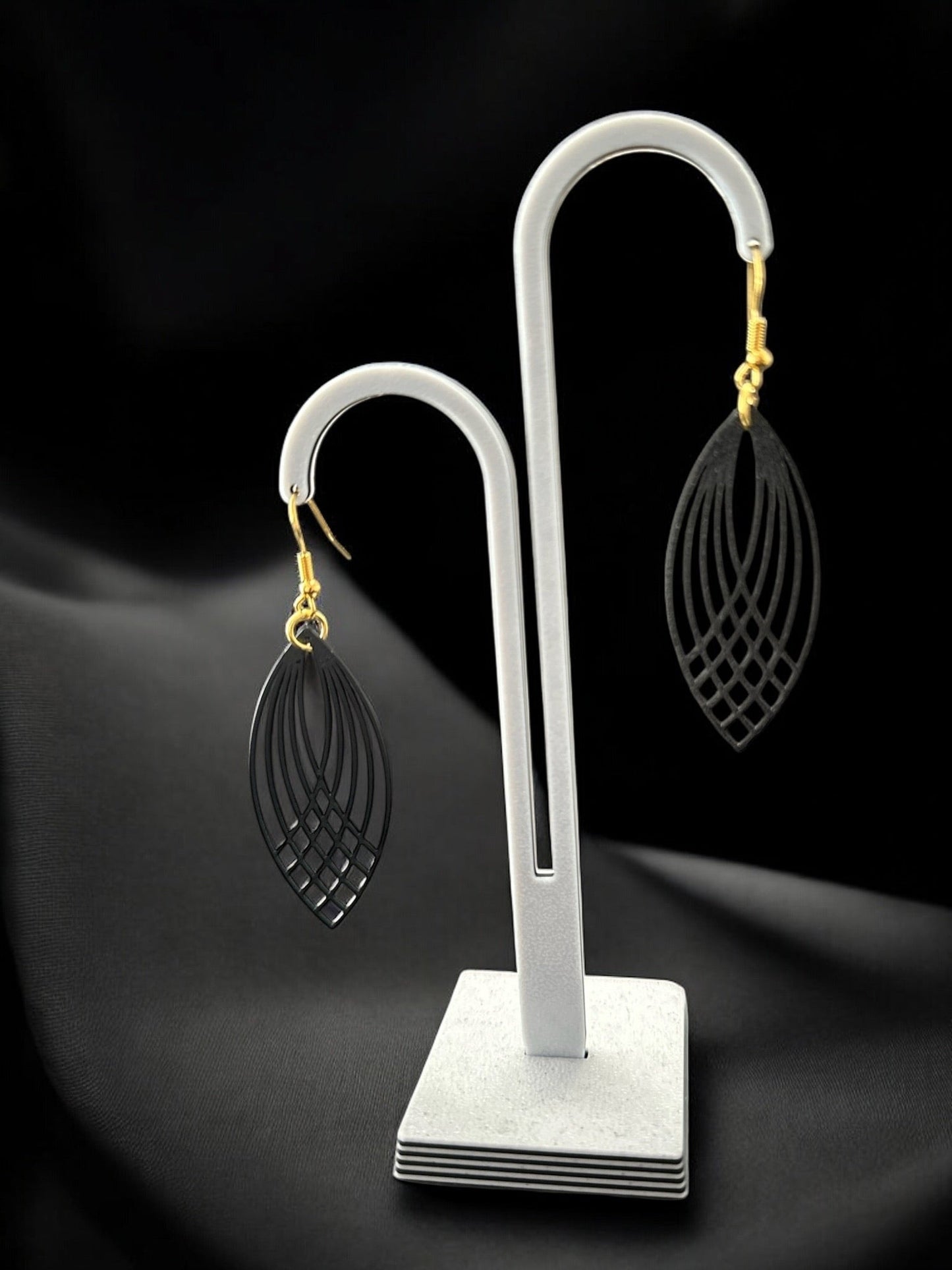 Boucles d'oreilles Pluma légères et ajourées en forme de plume, couleur menthe givrée, sur présentoir.