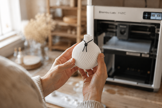 Artisan français tenant une pièce imprimée en 3D dans son atelier