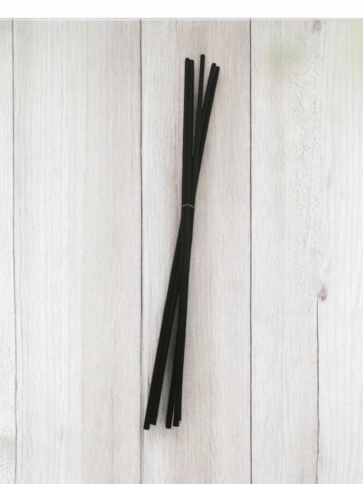 Bâtonnets diffuseurs pour aromathérapie luxueuse sur fond en bois.