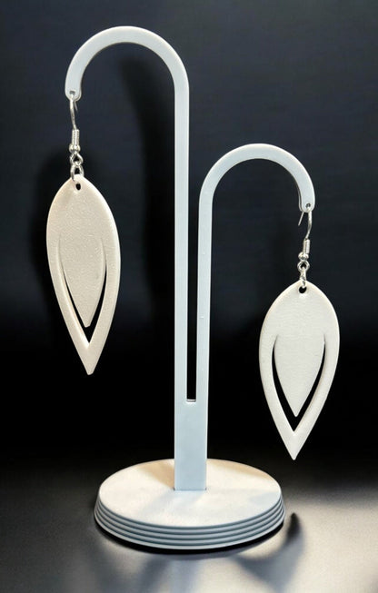 Boucles d'oreilles Luma en forme de goutte ajourée avec finition bronze, sur fond noir élégant.