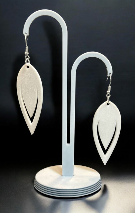 Boucles d'oreilles Luma en forme de goutte ajourée avec finition bronze, sur fond noir élégant.
