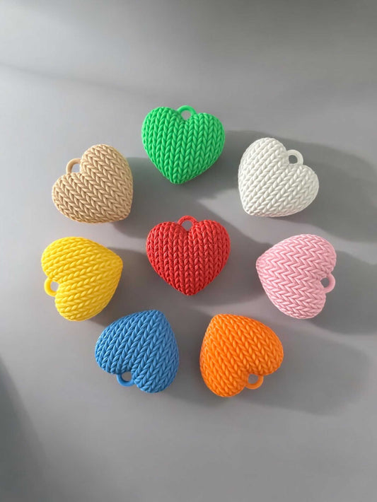 Heart-shaped 3D printed keychains in various colors arranged in a circle.