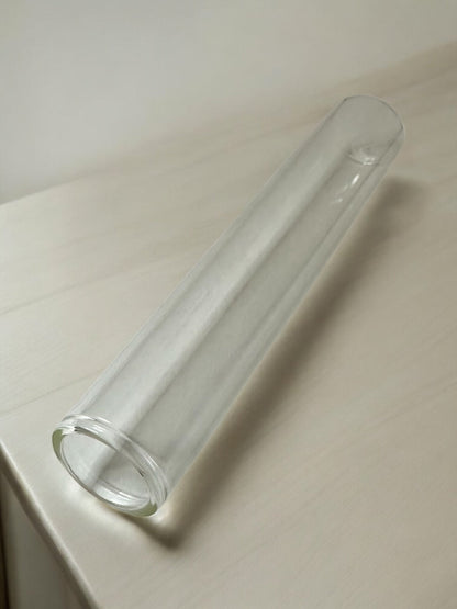 Tube en verre élégant pour diffuseur de parfum sur surface blanche.