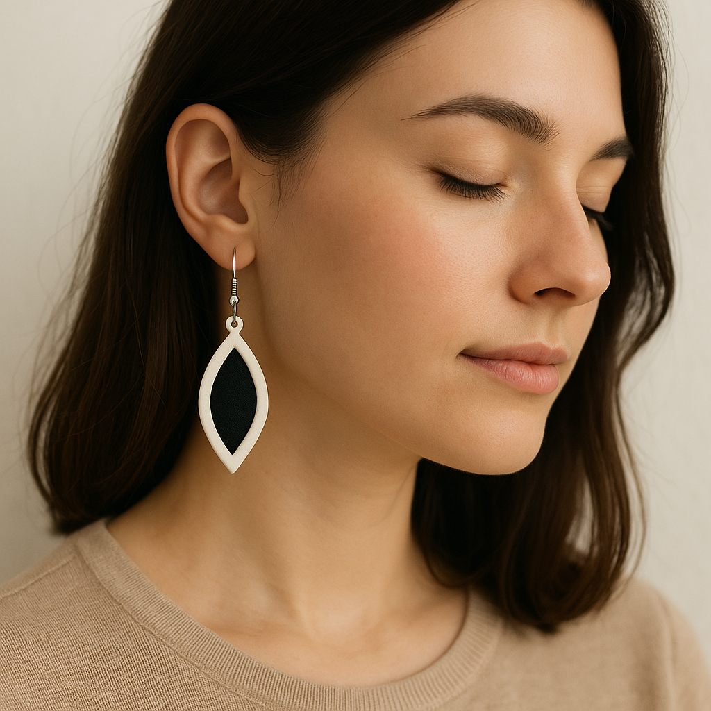 Boucles d'oreilles Élégance Bicolore, goutte allongée, blanc nacré et noir, sur modèle.