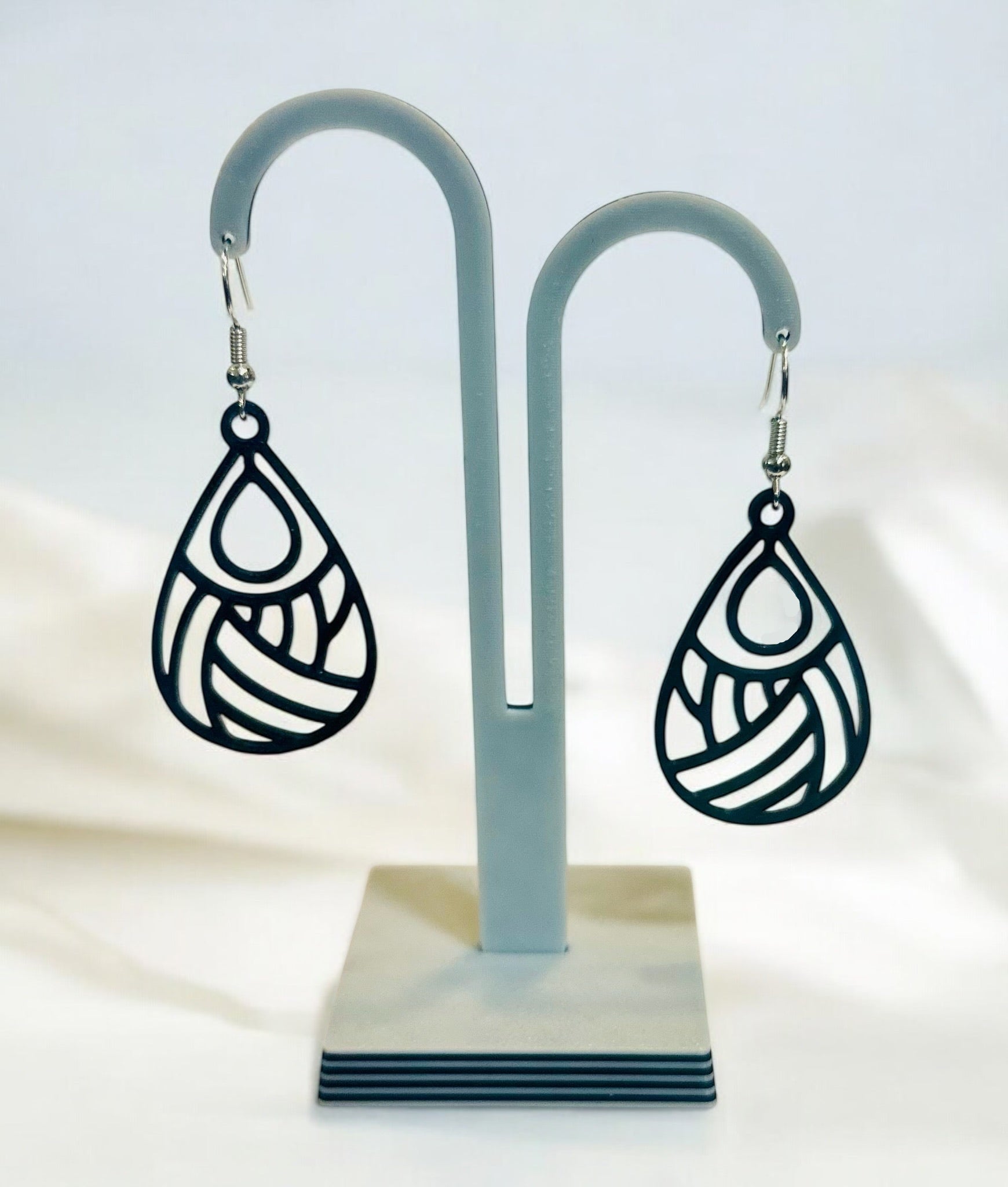 Boucles d'oreilles Dropa en forme de goutte ajourée avec attache argentée, design moderne et élégant.