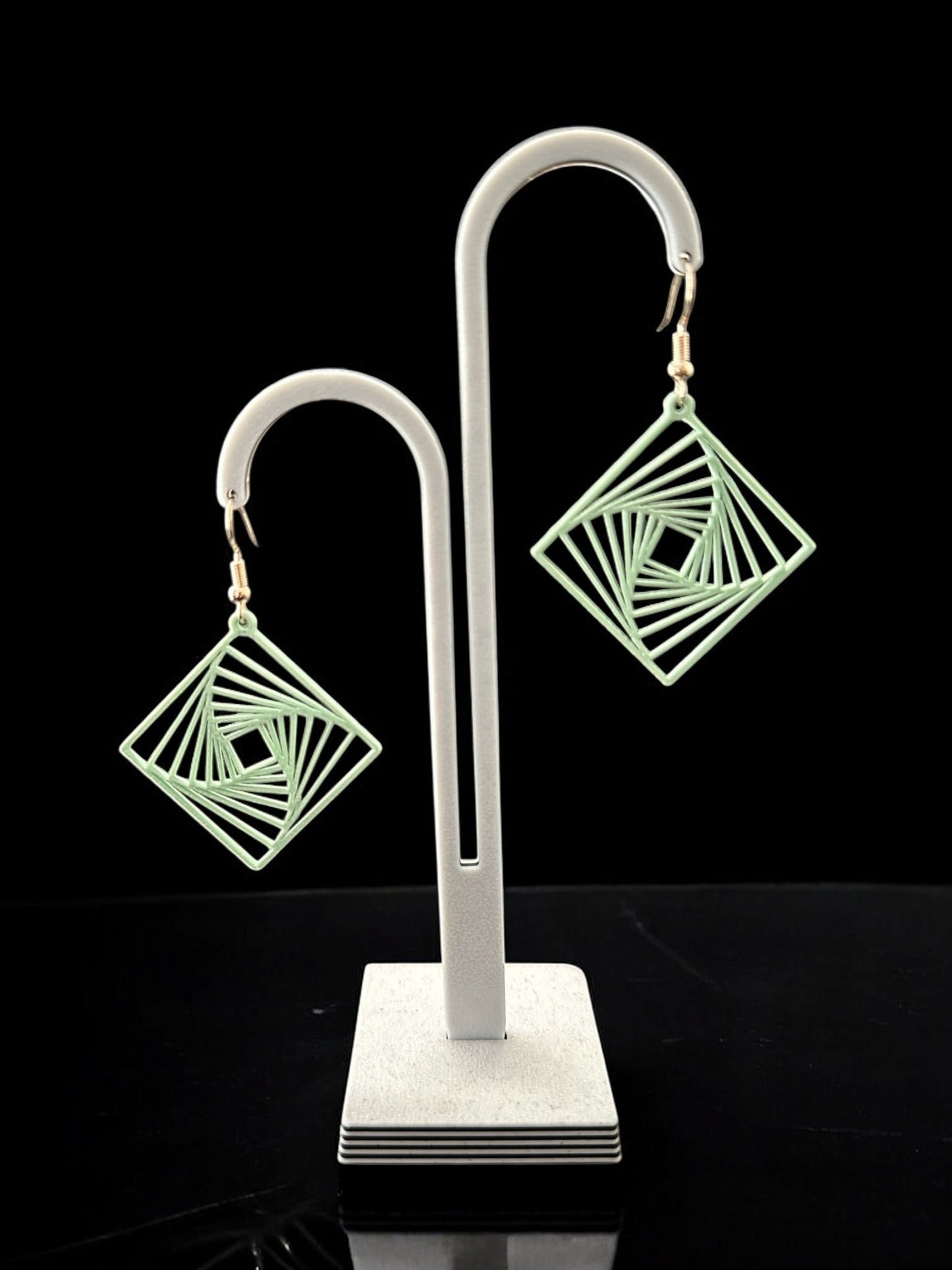 Boucles d'oreilles Twina en forme de losange, design géométrique spirale, finition ivoire mat.