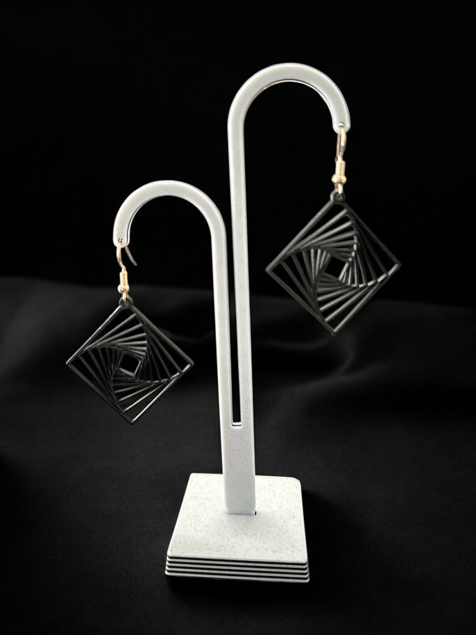 Boucles d'oreilles Twina en forme de losange spirale, design moderne ivoire mat, fabriquées en France.